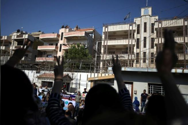 محتجون من الأكراد والعرب يشاركون في احتجاج ضد الرئيس التركي طيب أردوغان أمام مقر الأمم المتحدة بمدينة القامشلي السورية يوم الثلاثاء. تصوير. محمد حامد - رويترز